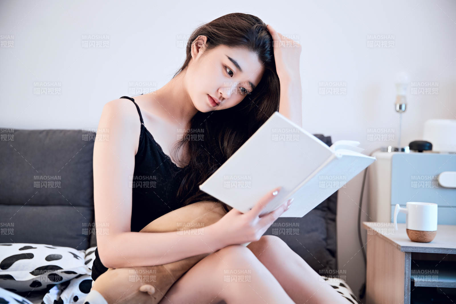 在床上阅读书籍的年轻女孩图片