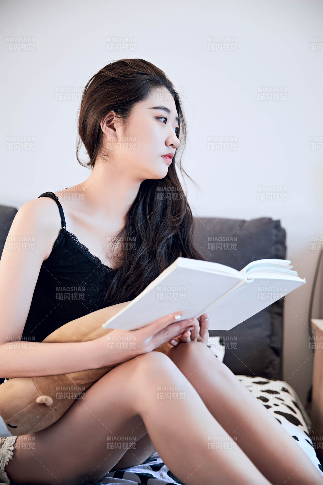 在床上阅读书籍的年轻女孩图片