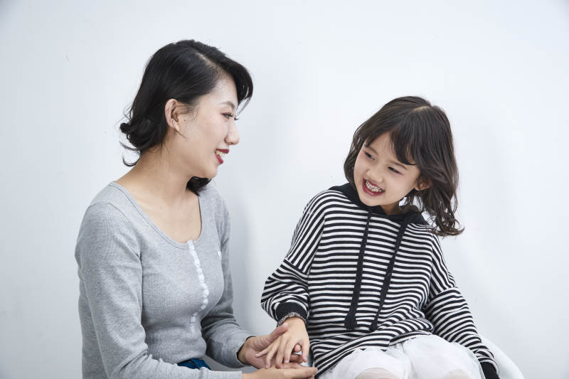 白色背景的美丽妈妈与可爱女儿亲子人像图片