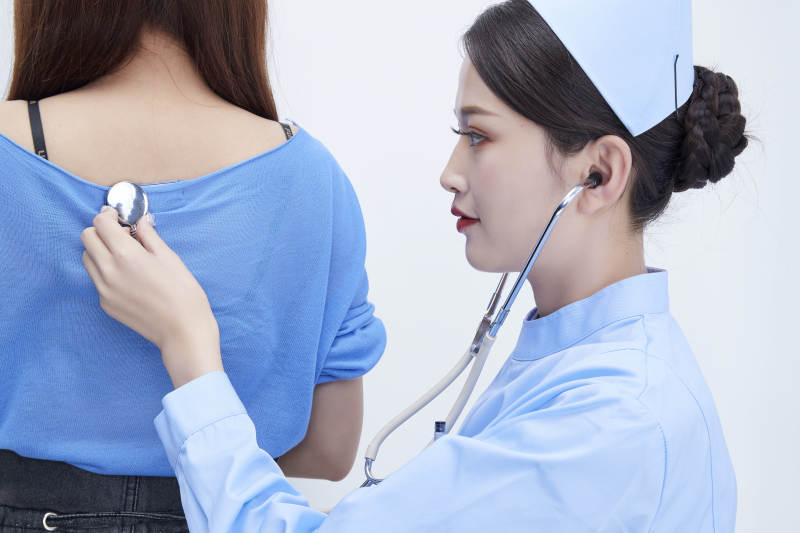 佩戴听诊器的女性医护人员为患者听诊检查图片