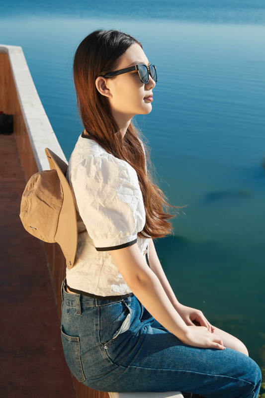 在湖畔木制帆船上的亚洲美女图片