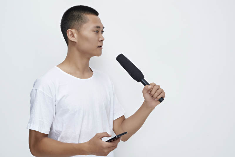 手持话筒手机进行采访的新闻工作者图片