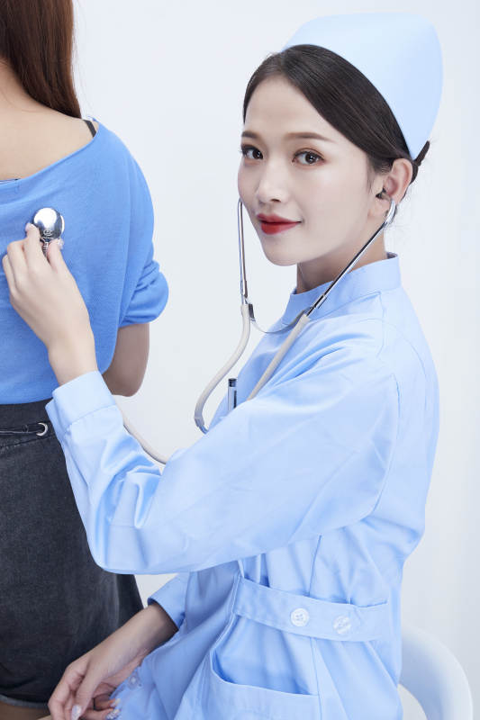佩戴听诊器的女性医护人员为患者听诊检查图片