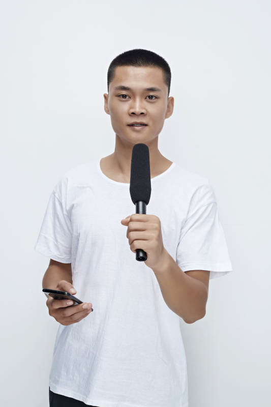 手持话筒手机进行采访的新闻工作者图片