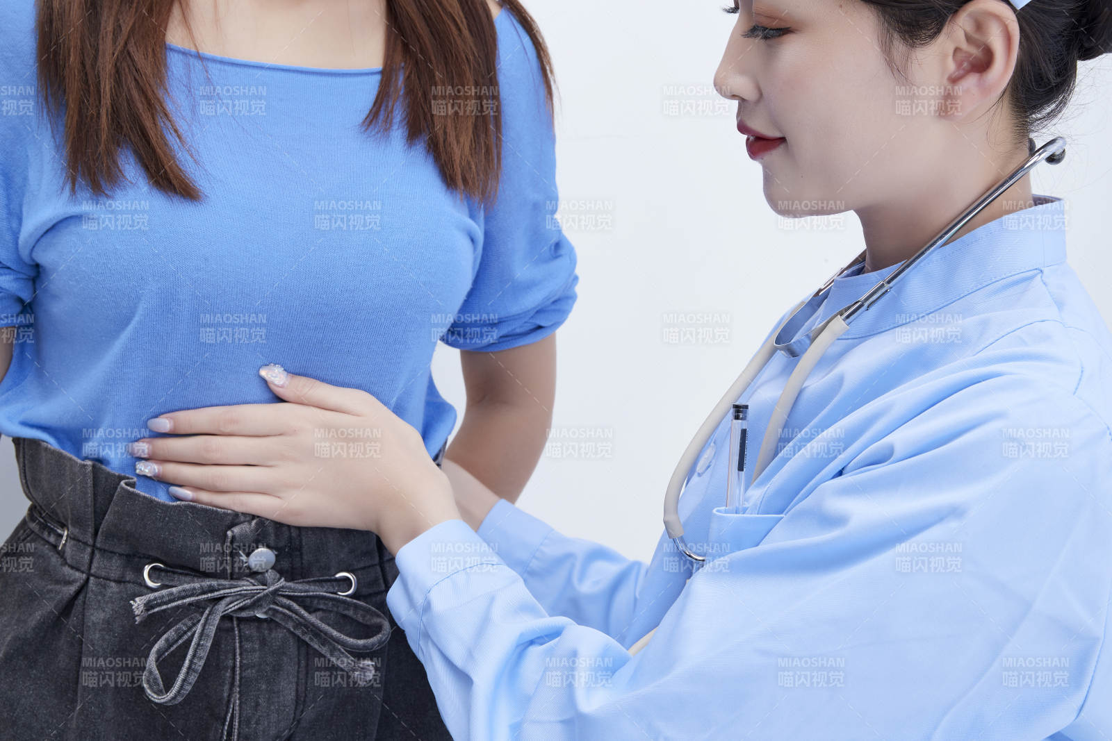 年轻的女性医护人员为患者进行身体按压检查图片