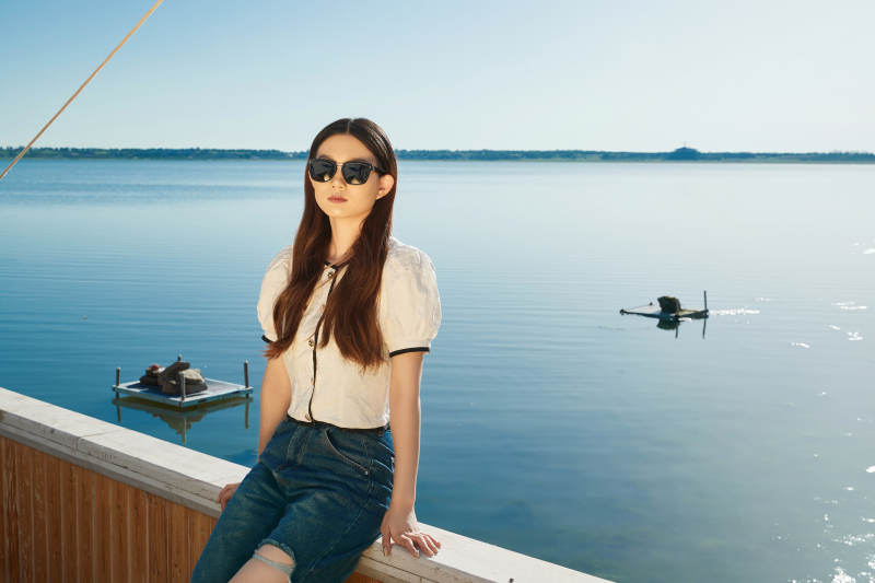 在湖畔木制帆船上的亚洲美女图片