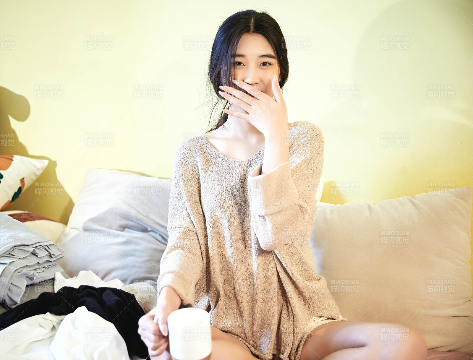 在沙发床上整理行装的年轻亚洲女性图片