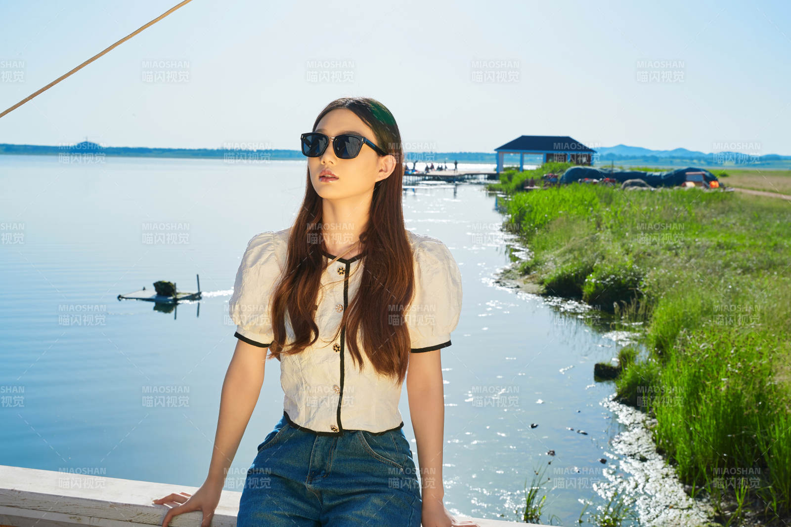 在湖畔木制帆船上的亚洲美女图片