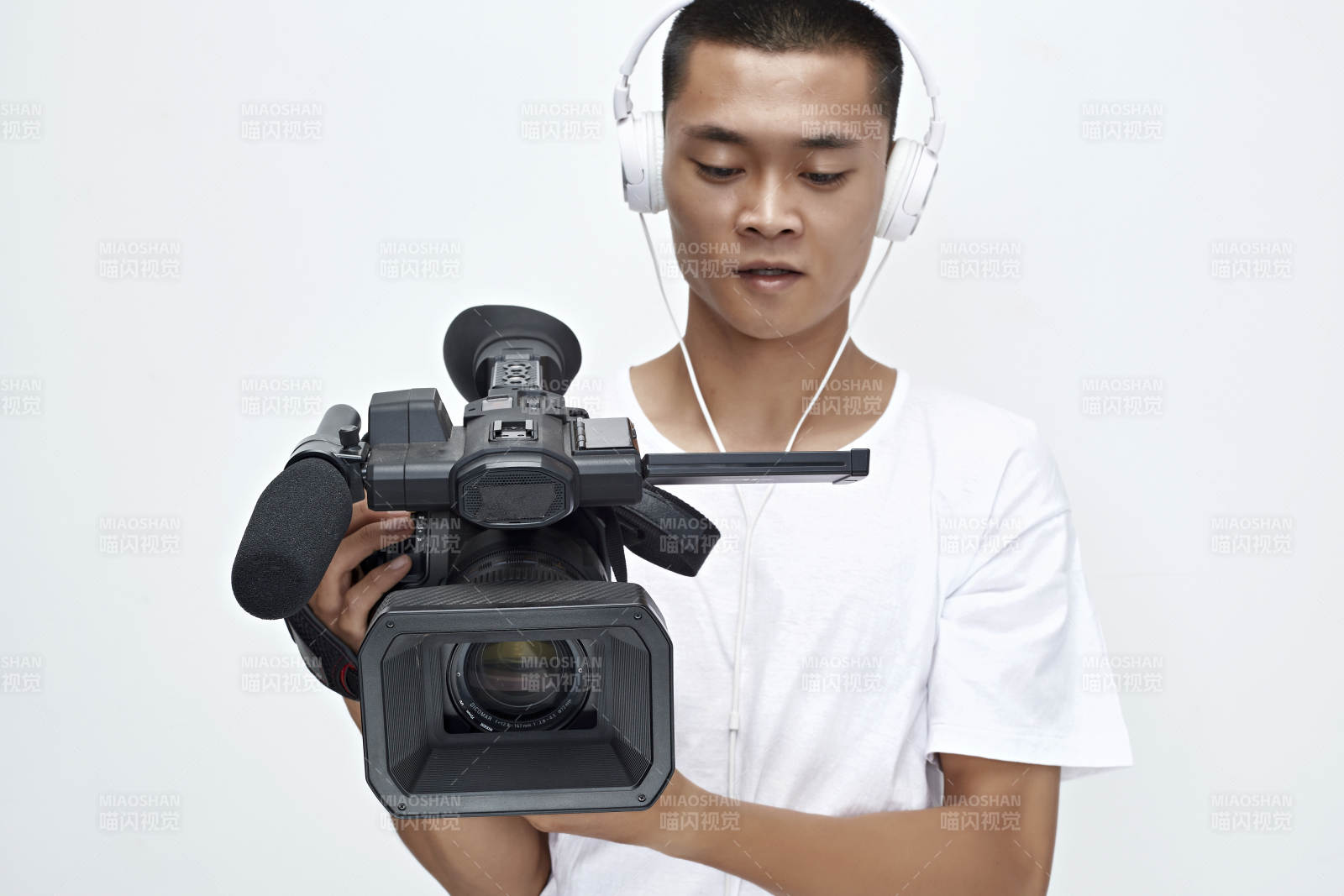 白色背景下手持摄像机进行录制拍摄的摄像师图片