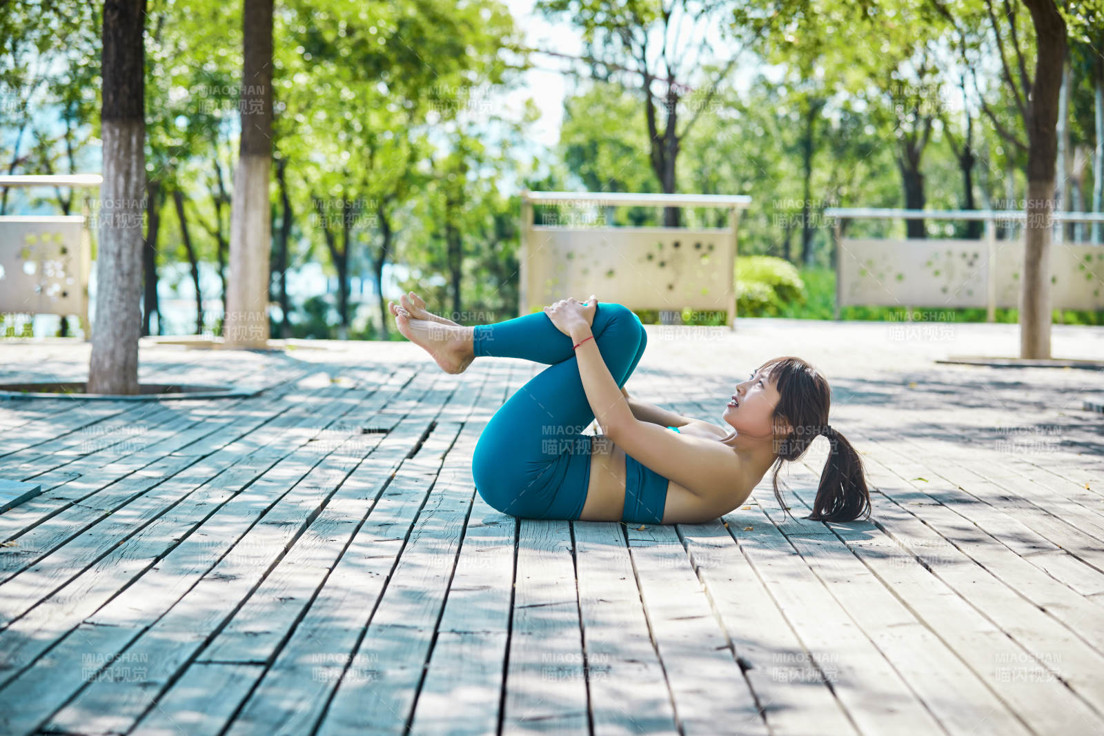 湖畔公园做瑜伽动作的亚洲年轻女性图片