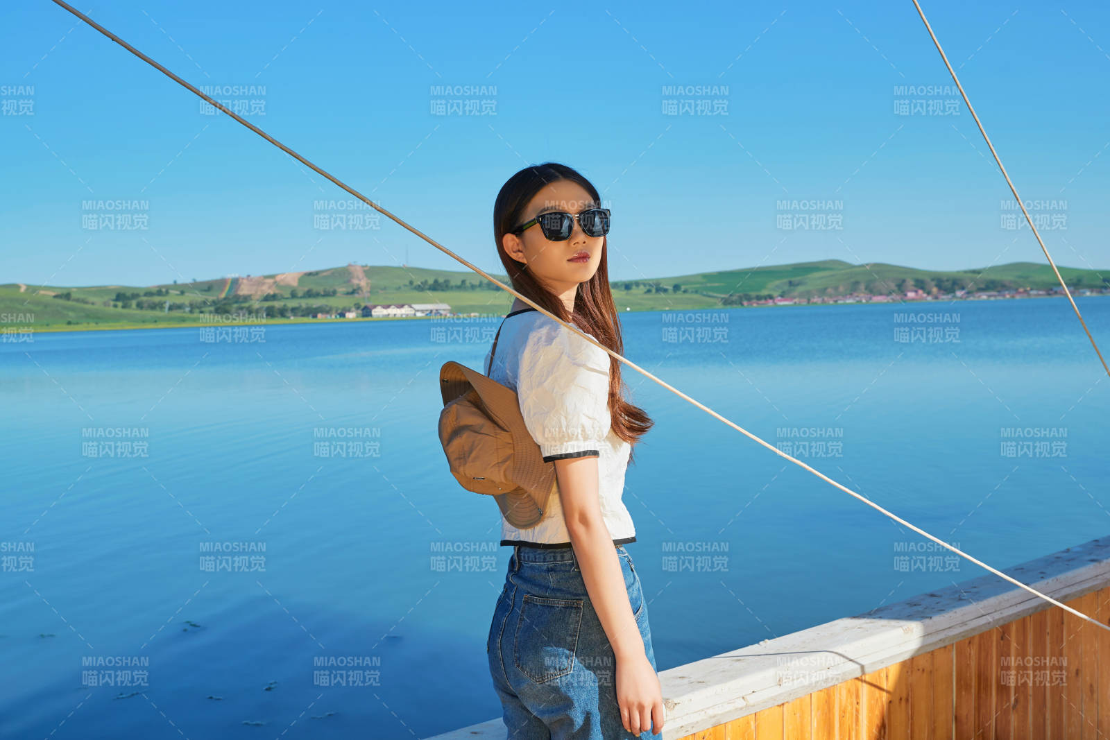 在湖畔木制帆船上的亚洲美女图片