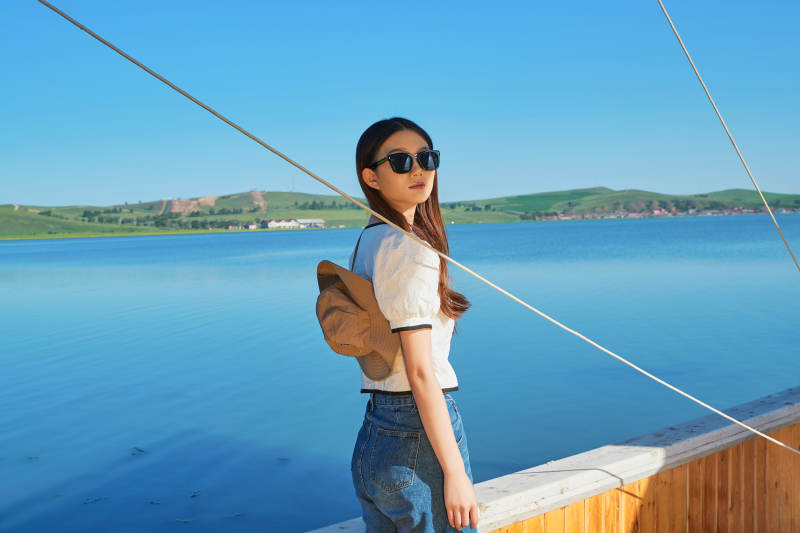 在湖畔木制帆船上的亚洲美女图片