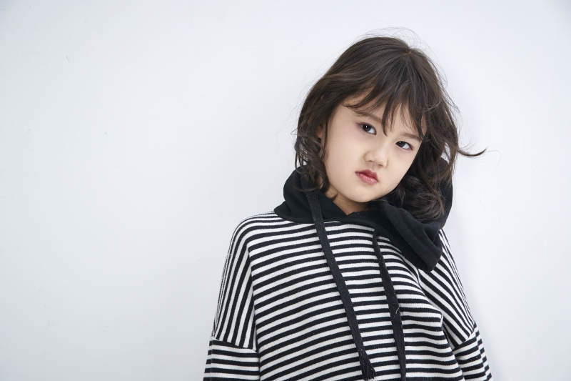 白色背景前身穿海魂衫的可爱的亚洲儿童人像图片