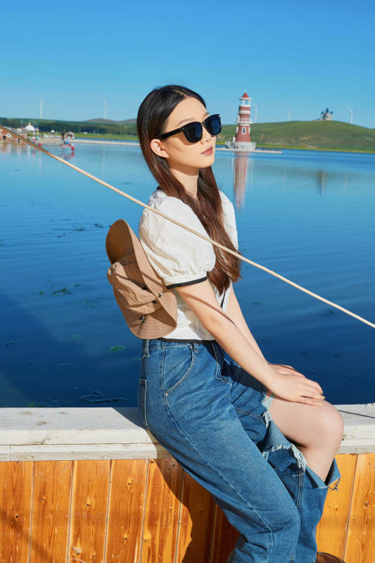 在湖畔木制帆船上的亚洲美女图片