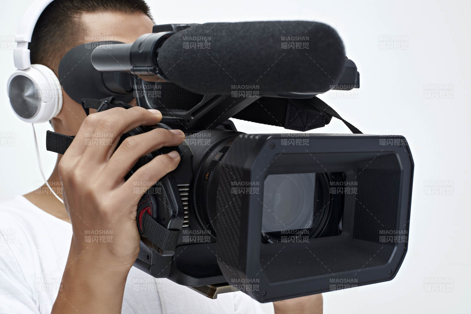 白色背景下手持摄像机进行录制拍摄的摄像师图片