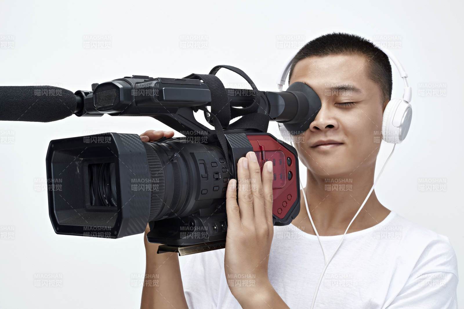 白色背景下手持摄像机进行录制拍摄的摄像师图片