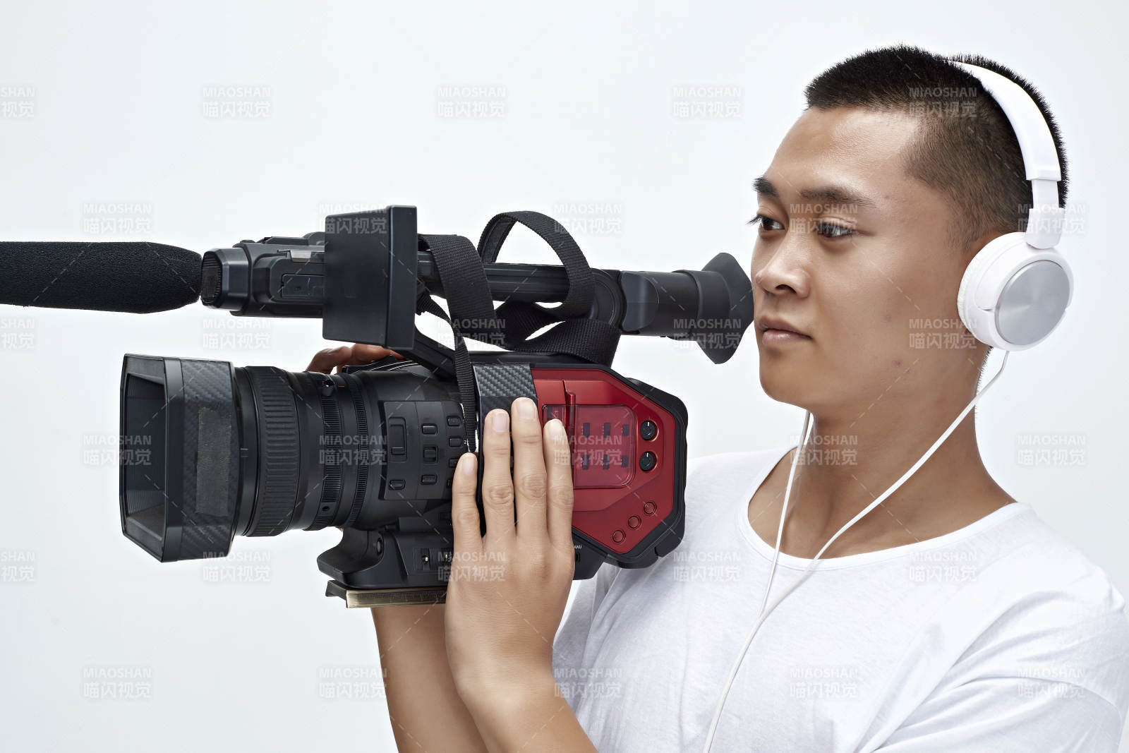 白色背景下手持摄像机进行录制拍摄的摄像师图片