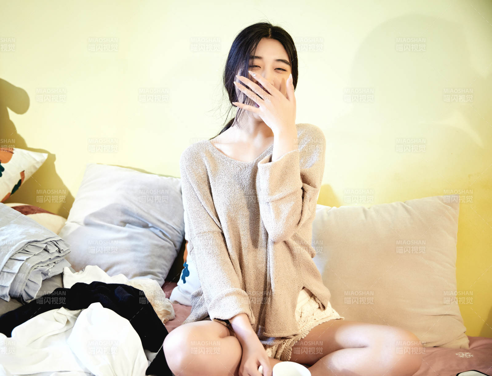 在沙发床上整理行装的年轻亚洲女性图片