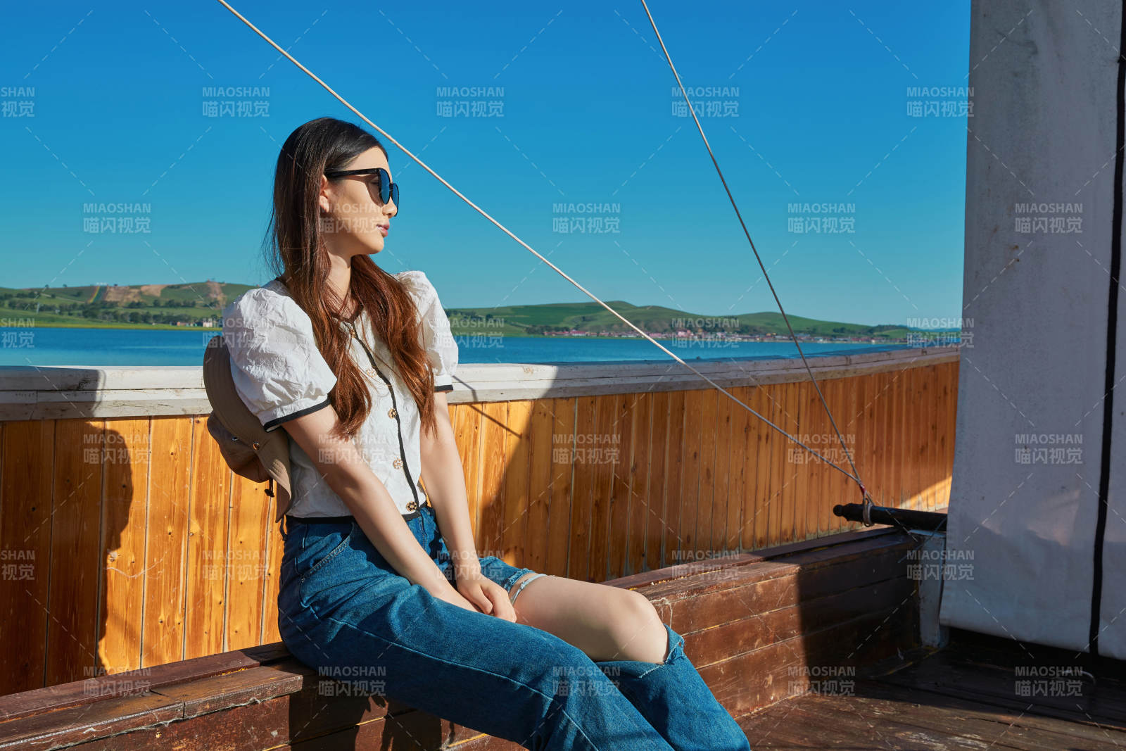 在湖畔木制帆船上的亚洲美女图片