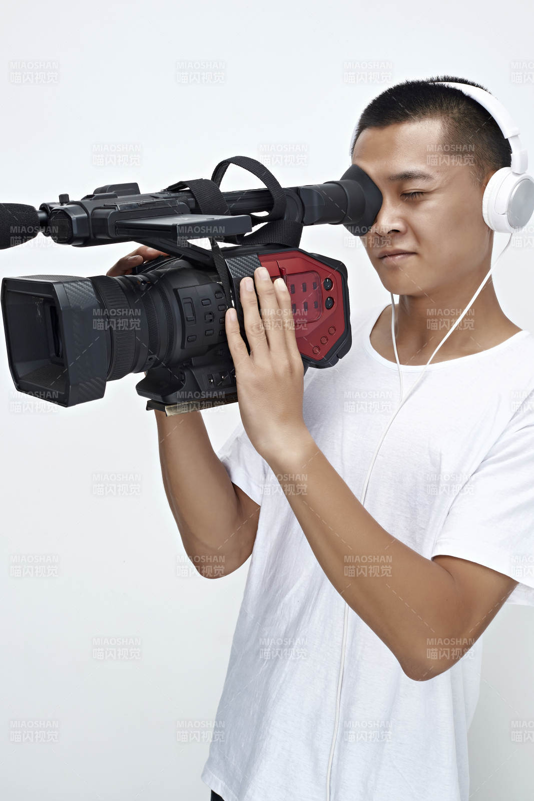 白色背景下手持摄像机进行录制拍摄的摄像师图片