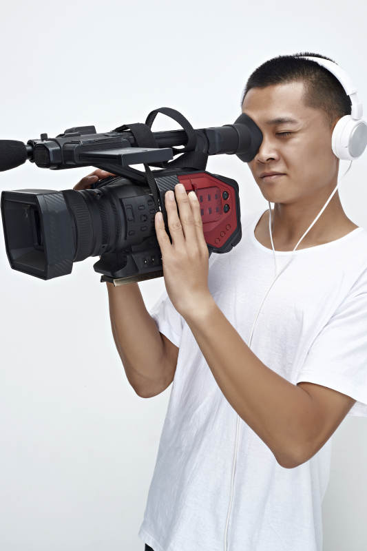 白色背景下手持摄像机进行录制拍摄的摄像师图片