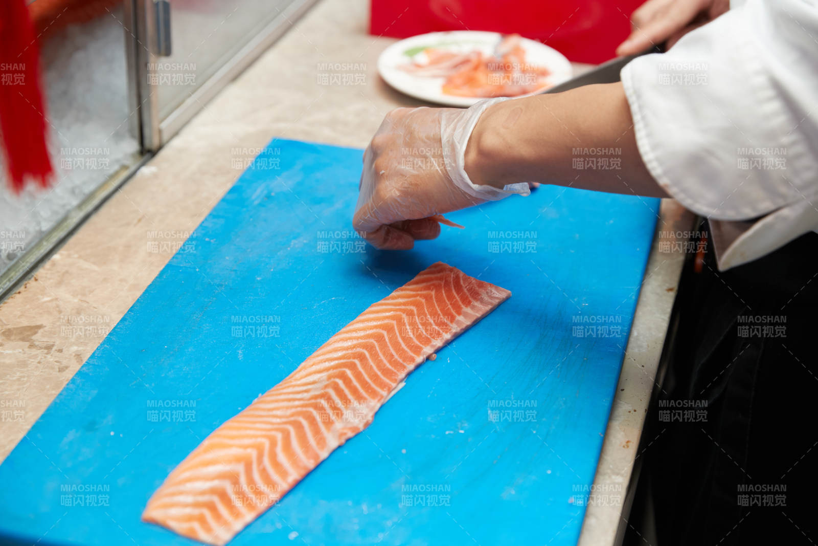 厨师切三文鱼做寿司卷图片