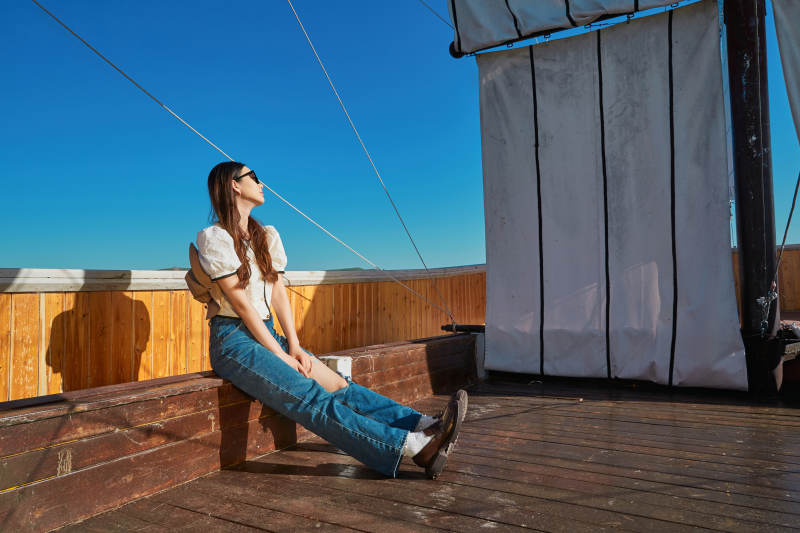 在湖畔木制帆船上的亚洲美女图片