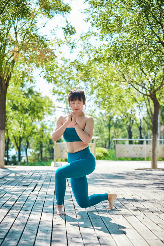 湖畔公园做瑜伽动作的亚洲年轻女性图片