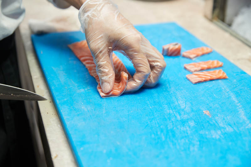 厨师切三文鱼做寿司卷图片