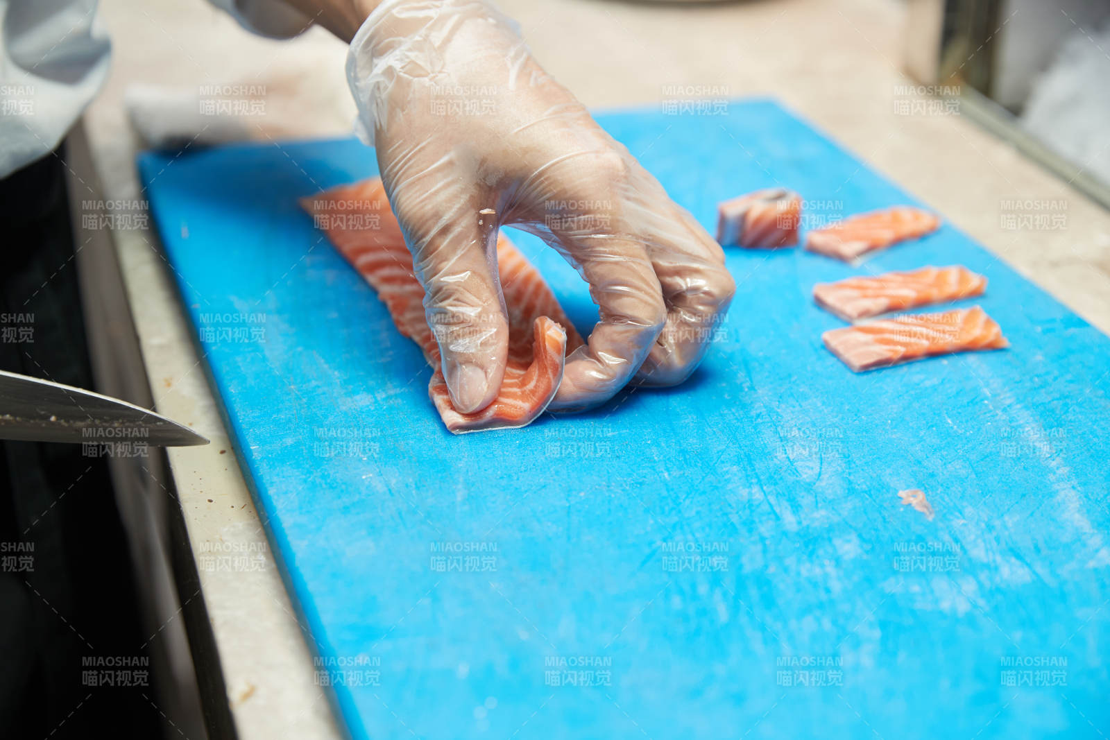 厨师切三文鱼做寿司卷图片