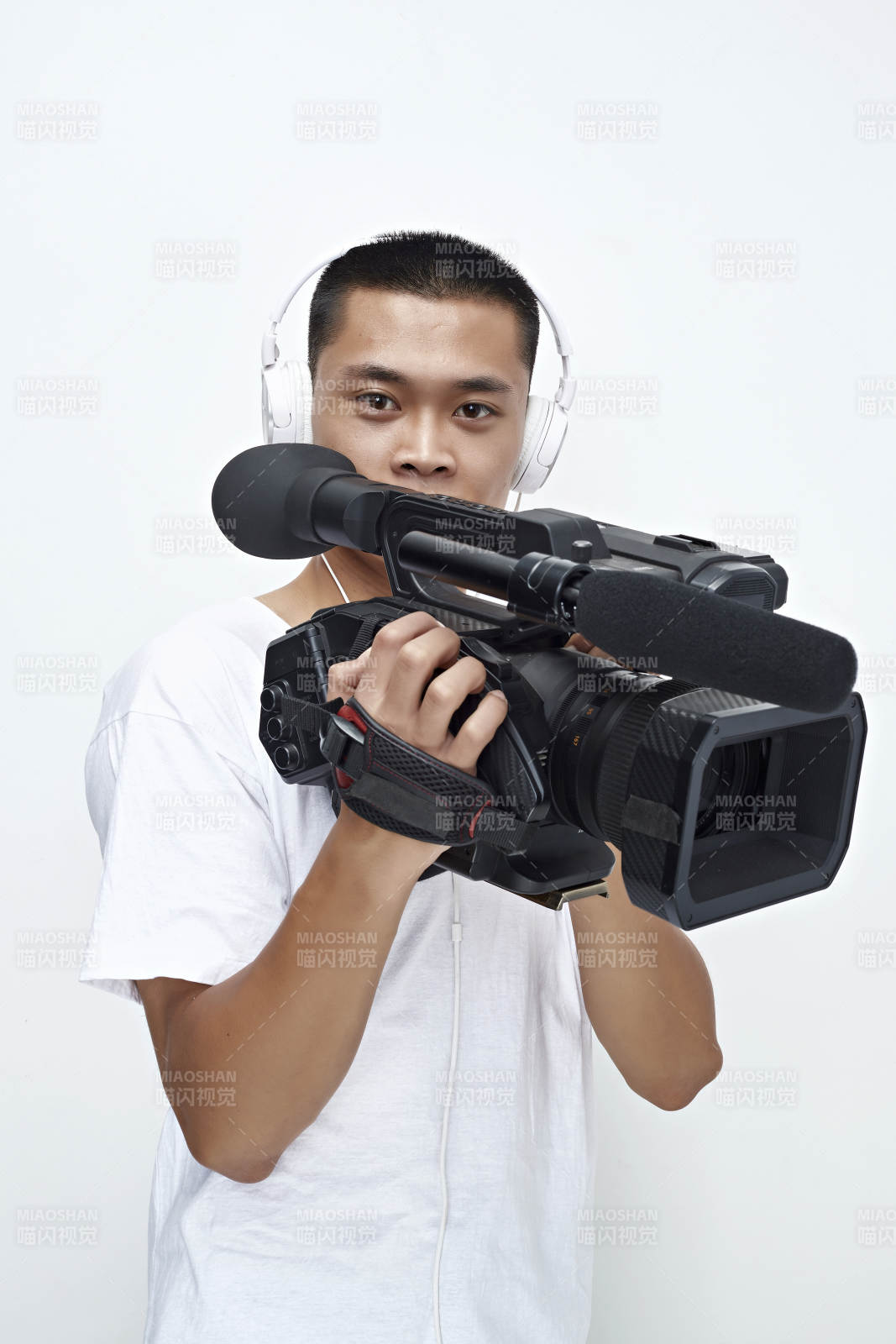 白色背景下手持摄像机进行录制拍摄的摄像师图片