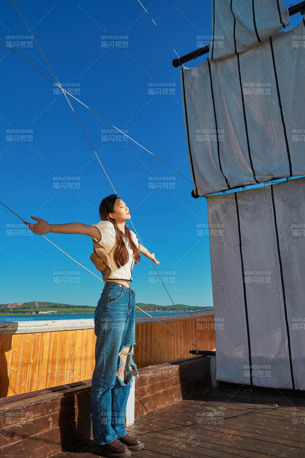 在湖畔木制帆船上的亚洲美女图片