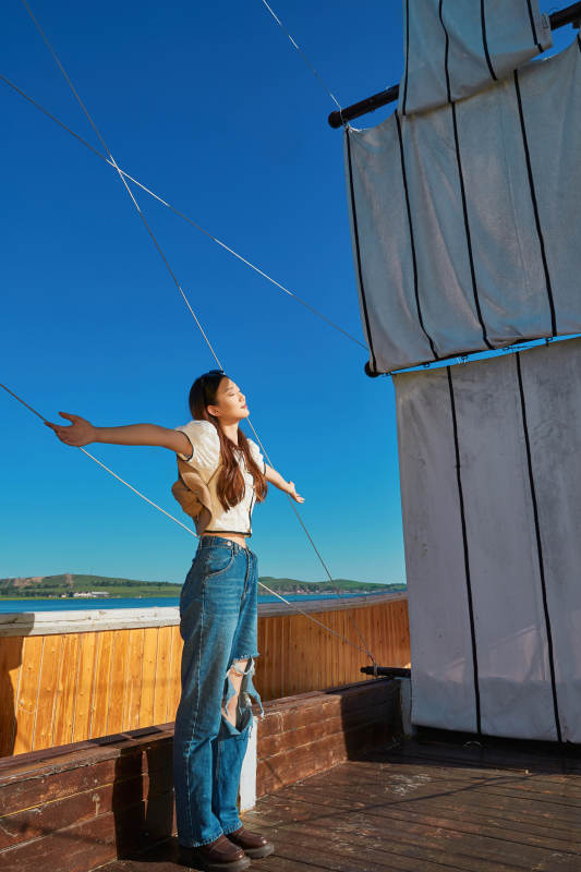 在湖畔木制帆船上的亚洲美女图片