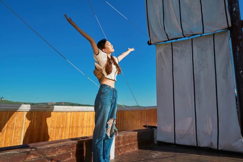 在湖畔木制帆船上的亚洲美女图片