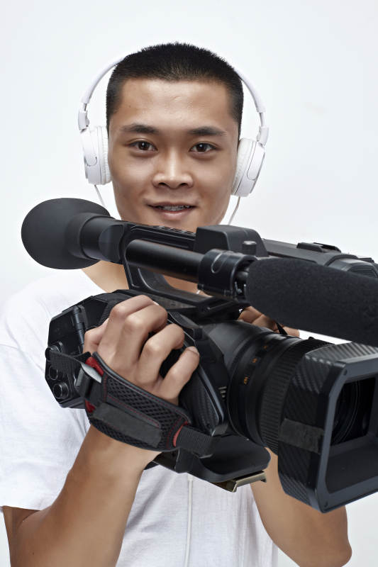 白色背景下手持摄像机进行录制拍摄的摄像师图片