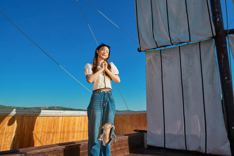 在湖畔木制帆船上的亚洲美女图片