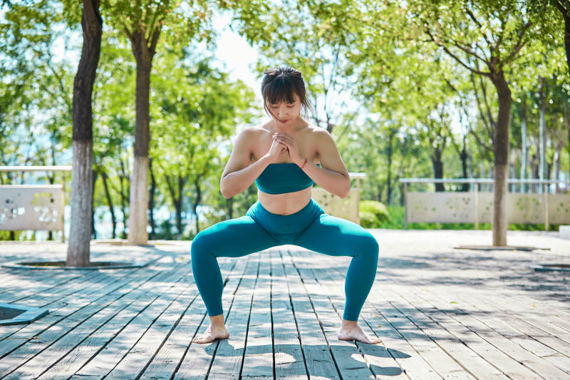 湖畔公园做瑜伽动作的亚洲年轻女性图片