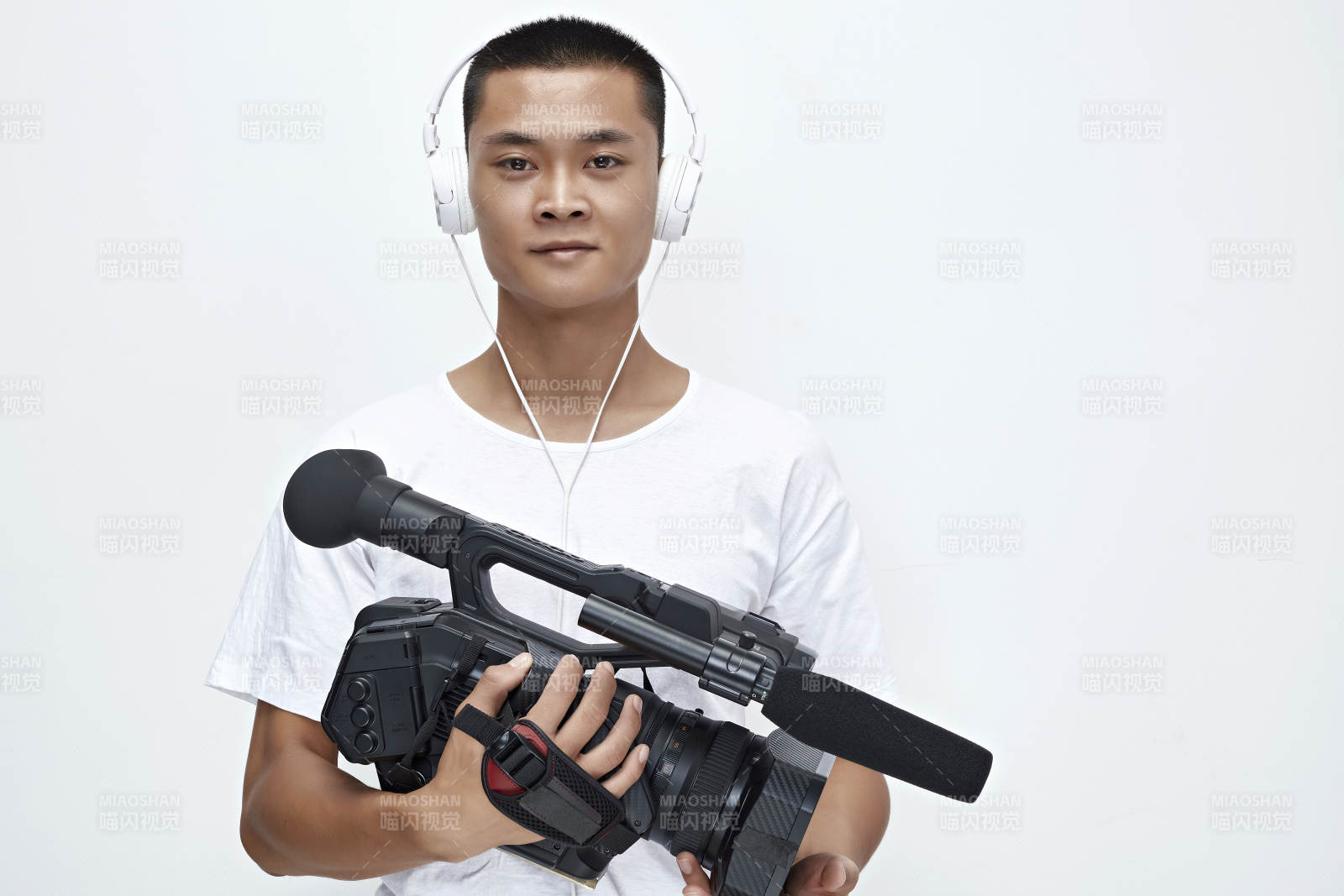 白色背景下手持摄像机进行录制拍摄的摄像师图片
