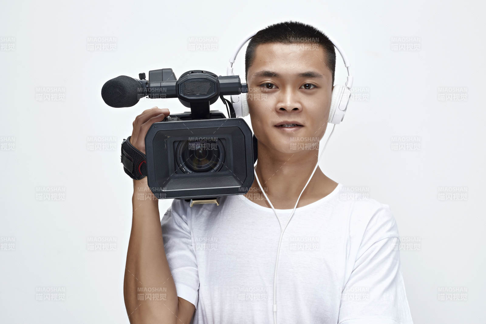 白色背景下手持摄像机进行录制拍摄的摄像师图片
