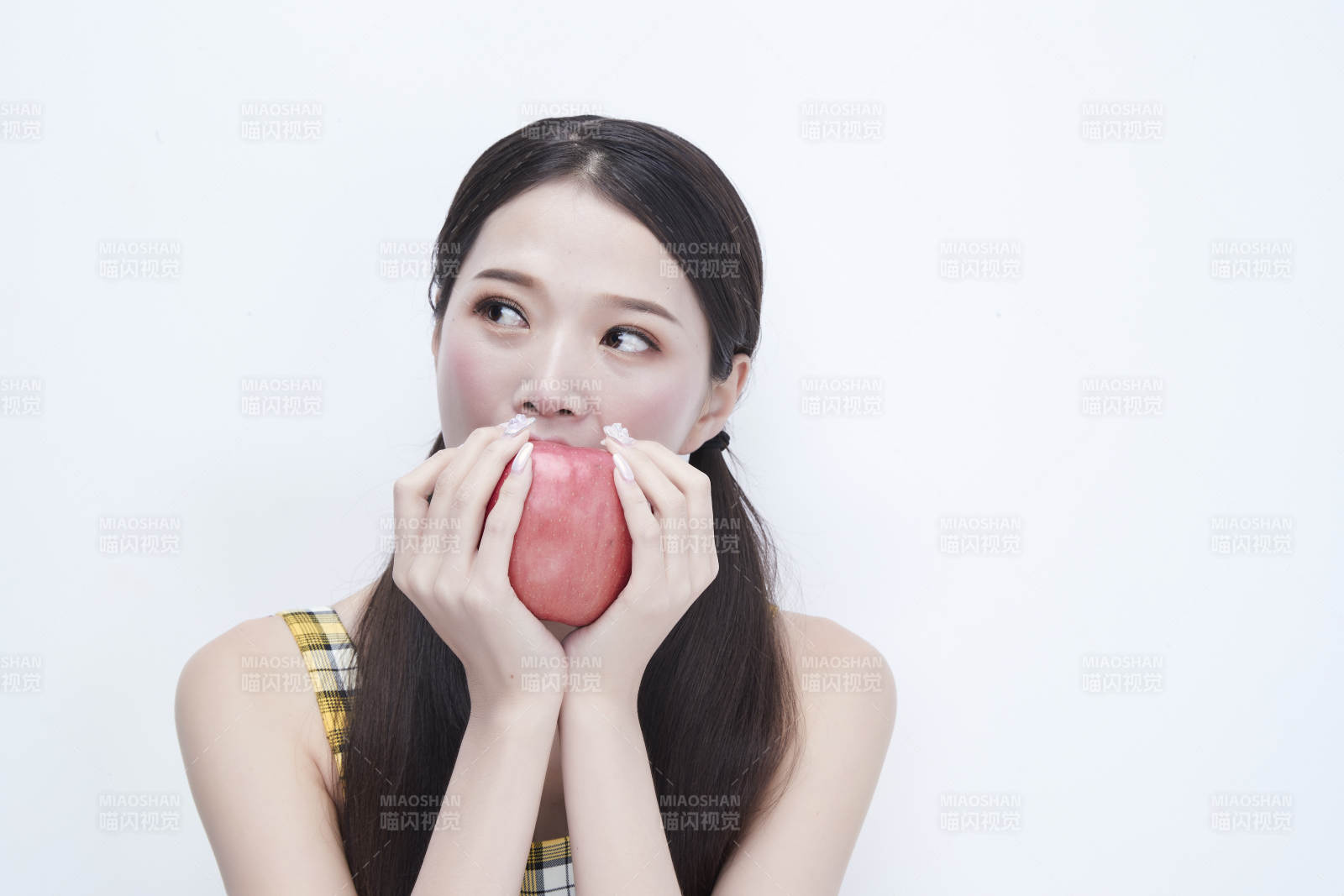 手拿苹果身穿格子吊带裙的亚洲可爱少女人像图片