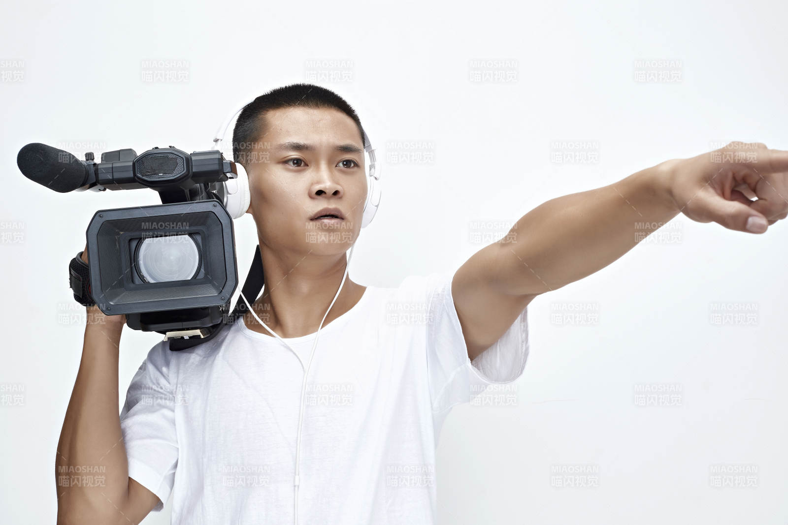 白色背景下手持摄像机进行录制拍摄的摄像师图片