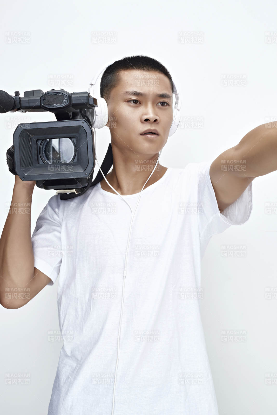 白色背景下手持摄像机进行录制拍摄的摄像师图片