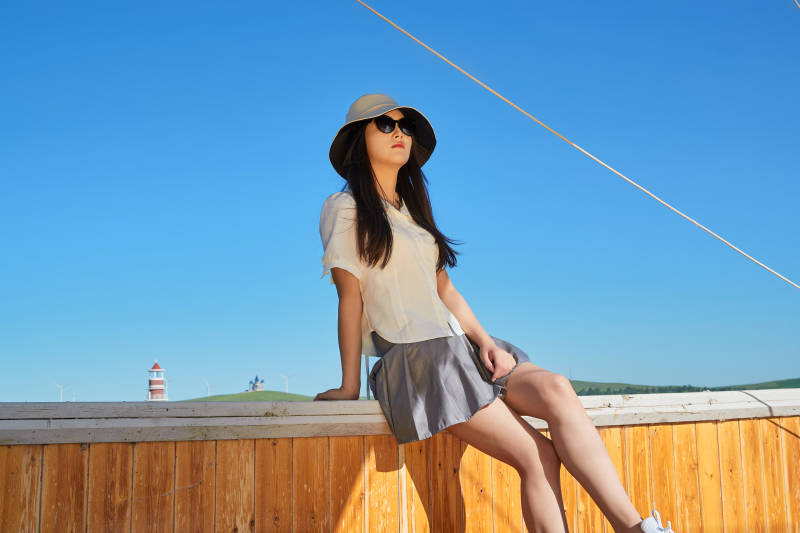 在湖畔木制帆船上的亚洲美女图片