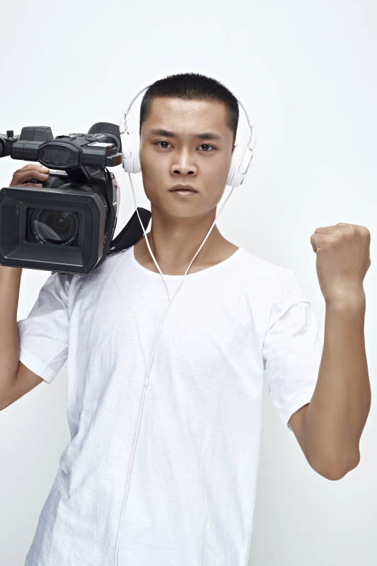 白色背景下手持摄像机进行录制拍摄的摄像师图片