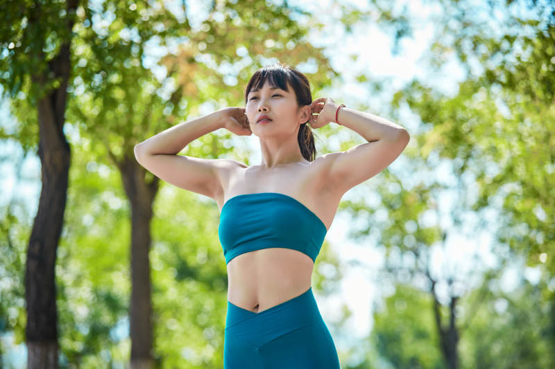 湖畔公园做瑜伽动作的亚洲年轻女性图片