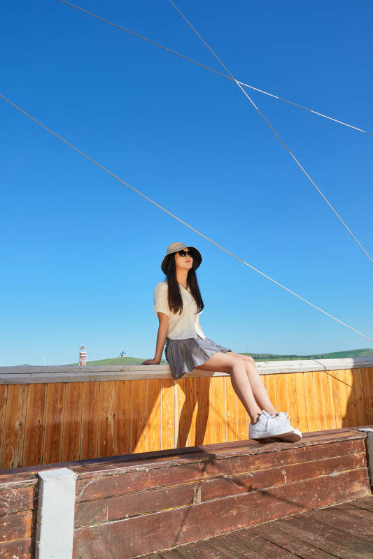 在湖畔木制帆船上的亚洲美女图片