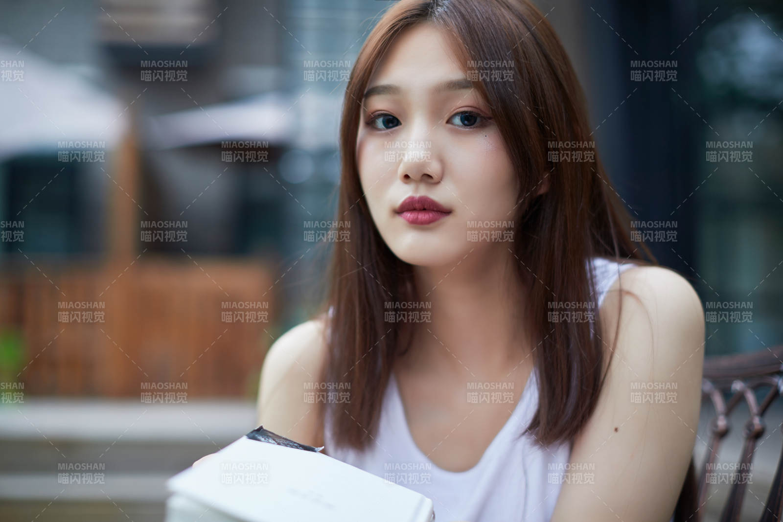 院子里坐在长椅上阅读书籍的亚洲长发少女图片