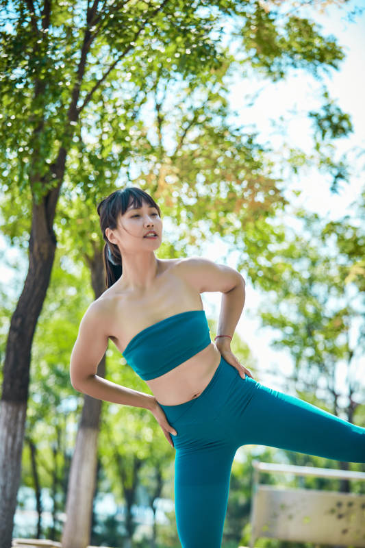 湖畔公园做瑜伽动作的亚洲年轻女性图片