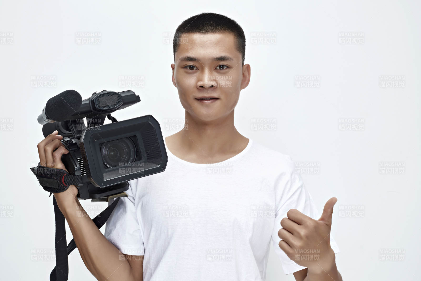 白色背景下手持摄像机进行录制拍摄的摄像师图片