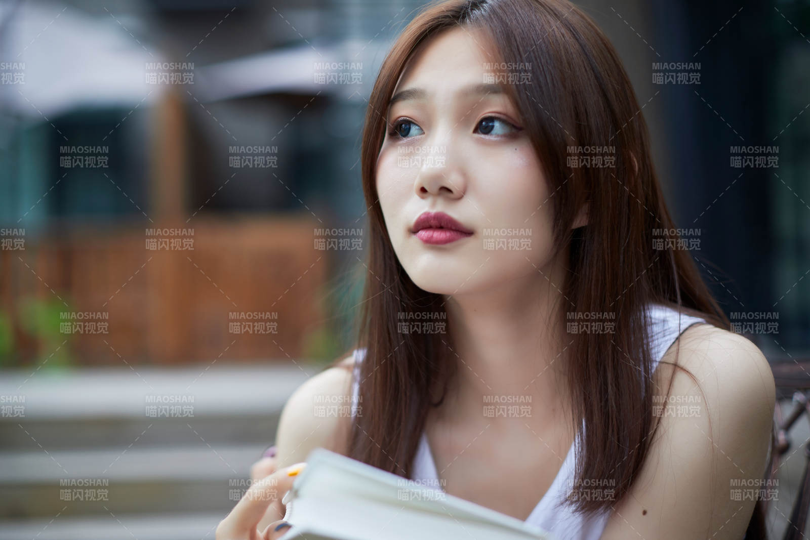 院子里坐在长椅上阅读书籍的亚洲长发少女图片